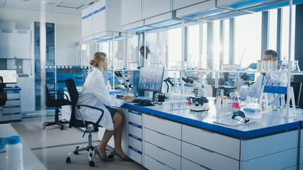 Wall Mural - medical science laboratory with diverse team of professional scientists working with microscopes, co
