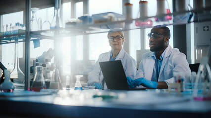 Wall Mural - bright medical science laboratory with diverse team of research scientists working. young female mic