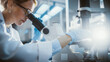 © Gorodenkoff - Bright Medical Science Laboratory: Beautiful Microbiologist Looks Under Microscope Does Analysis of Test Sample. Brilliant Scientist, Doctor, working with High-Tech Equipment. Close-up with Sun Flare.