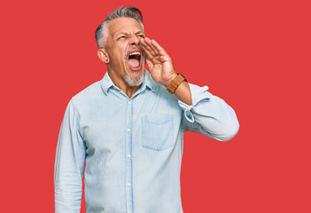 Sticker - Middle age grey-haired man wearing casual clothes shouting and screaming loud to side with hand on mouth. communication concept.