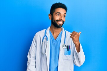 Poster - Handsome hispanic man with beard wearing doctor uniform and stethoscope pointing thumb up to the side smiling happy with open mouth