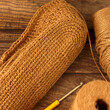 © TaniaA - Photo of crocheting of jute shopping bag and two bobbins of jute yarn on wood background