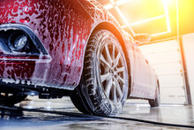 Washing Red Car With Active Foam At Car Wash Service.