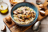 Fototapeta Mapy - Risotto with brown champignon mushrooms on wooden background. 