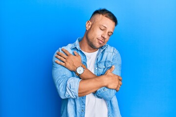 Sticker - Handsome muscle man wearing casual denim jacket hugging oneself happy and positive, smiling confident. self love and self care