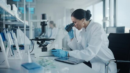 Wall Mural - medical development laboratory: portrait of beautiful caucasian female scientist looking under micro