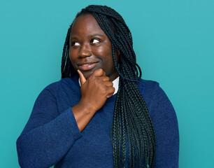 Poster - Young black woman with braids wearing casual clothes with hand on chin thinking about question, pensive expression. smiling with thoughtful face. doubt concept.