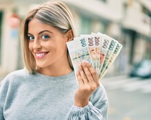 Young Blonde Girl Smiling Happy Holding Czech Koruna Banknotes At The City.
