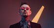 © Fxquadro - Weared with sunglasses stylish and tattooed businessperson with fashionable haircut and beard poses in dark and colourful background with lights.