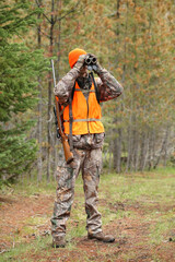 adult deer hunter looking through binoculars