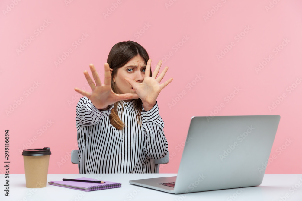 No, I'm scared! Frightened woman with shocked expression raising hands in stop gesture, defending herself, freaked out of troubles working on laptop. Indoor studio shot isolated on pink background - obrazy, fototapety, plakaty 