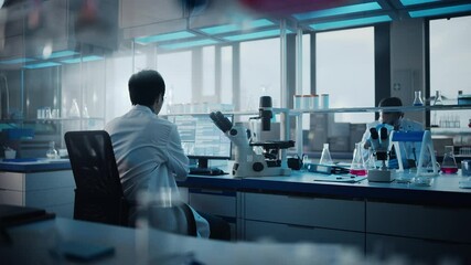 Wall Mural - medical development laboratory: back view of japanese male scientist using touch screen digital tabl