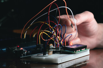 Wall Mural - man learns the basics of programming microprocessors close up.