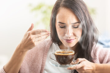 Canvas Print - Brunette enjoys the smell of freshly made coffee in a cup