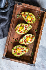 Wall Mural - Avocado egg boats with bacon and green onion