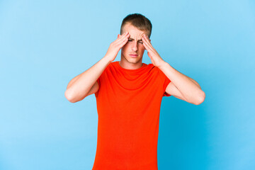 Young caucasian handsome man having a head ache, touching front of the face.