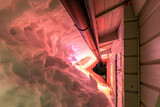Fototapeta  - Night photo of snow drifts, slides down off the roof and freeze if form of ice stripes. Snow illuminated by light through window from inside of cabin. Joesjo village, Lappland, Northern Sweden.