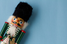 Interesting Beautiful Christmas Nutcracker Soldier On Blue Colored Paper Surface Texture With Copy Space.