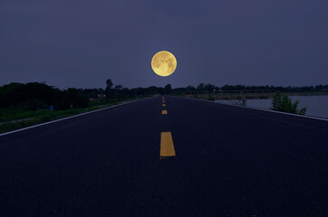 Wall Mural - Yellow lines on long road to big full moon