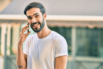 Young hispanic man smiling happy talking on the smartphone at the city.