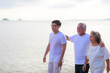 © sutthichai - Happy family walking relax on the beach.