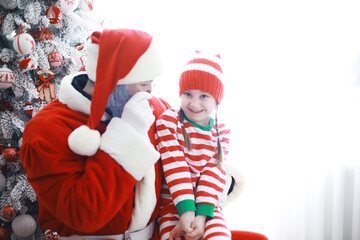 Santa Claus sitting with little cute elves over Christmas background. Time of miracles. Gifts from Santa Claus.