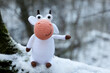 White knitted toy bull on a snow in winter park, New Year greeting card. Chinese Year of Bull, Zodiac symbol 2021