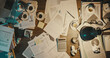 © stokkete - Messy office desk with paperwork and coffee cups