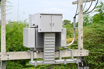 AC high voltage transformers to supply electricity, installed on cement poles, transfer electrical energy to an office building or house. Two-phase transformer, dual voltage, 1000 kVA
