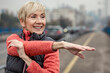 © Zoran Zeremski - Active senior woman stretches her muscles before running through the city during the day.