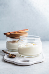 Wall Mural - Homemade yogurt in glass jars, light background, copy space. Yoghurt preparation concept.