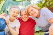 Three laughing seniors on the campsite