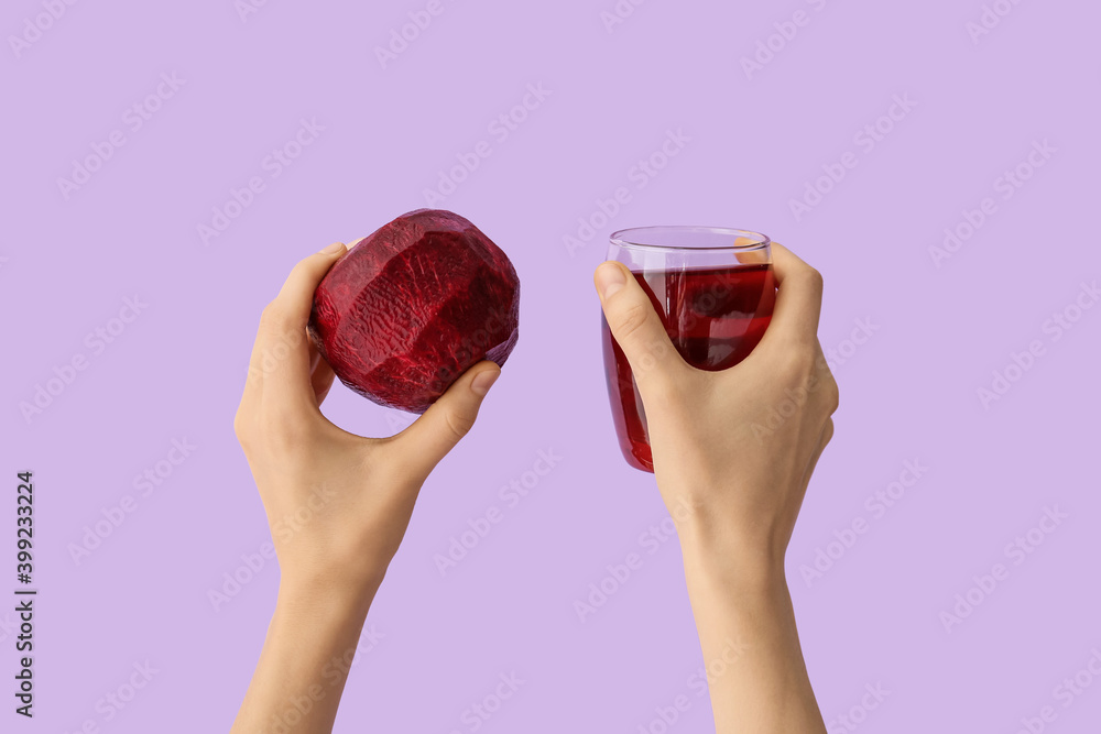 Hands with glass of beetroot juice on color background