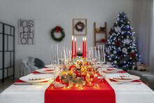 Beautiful Table Setting With Christmas Decorations At Home In Evening