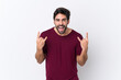 © luismolinero - Young handsome man with beard over isolated white background making rock gesture
