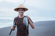 © Odua Images - Close up young fisherman showing his captured fish on the beach
