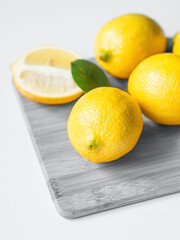 Wall Mural - Yellow lemons on grey wood cutting board