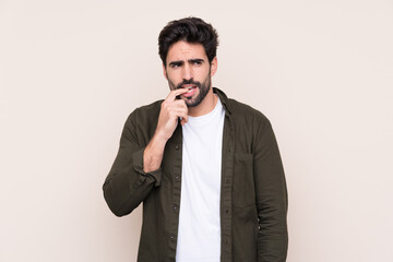 Wall Mural - Young handsome man with beard over isolated background nervous and scared