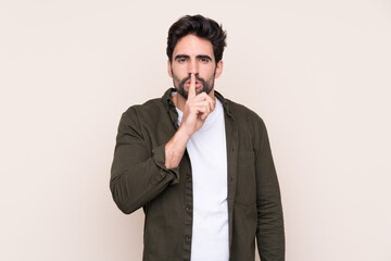 Wall Mural - Young handsome man with beard over isolated background showing a sign of silence gesture putting finger in mouth