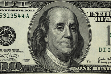 United States hundred dollars money bill closeup. Portrait of US president Benjamin Franklin on 100 dollars banknote macro fragment.