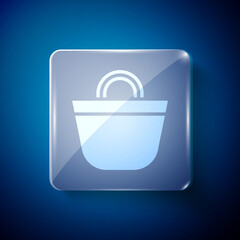 Wall Mural - White Beach bag icon isolated on blue background. Square glass panels. Vector.