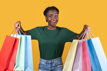 Joyful Female Buyer On Shopping Posing With Bags, Yellow Background