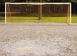 © Mint Images - Goal net on muddy soccer field.