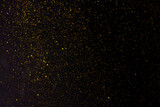 Fototapeta Tulipany - Golden falling glitter on the black background, festive overlay