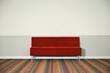 © Mint Images - Red sofa on striped carpet.