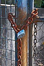 Rusty Chain And Padlock On A Metal Fence Gate.