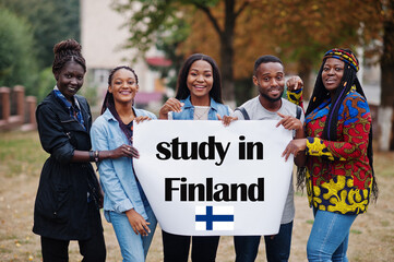 Wall Mural - Study in Finland. Group of five african college students on campus at university yard hold white blank. Abroad countries for student concept.