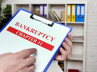 Wall Mural - The banker reads the chapter 11 of the bankruptcy law.