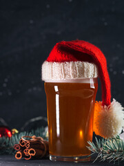 Canvas Print - Seasonal craft beer with cinnamon, glass in Santa's red hat close-up, Christmas time