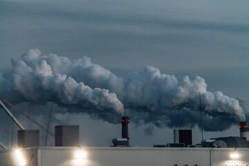 industrial chimneys with smoke on gray sky background. Smokestack Pollution in the air as environmental problem